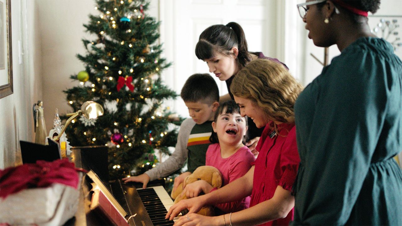 Missionárias tocando piano para uma família