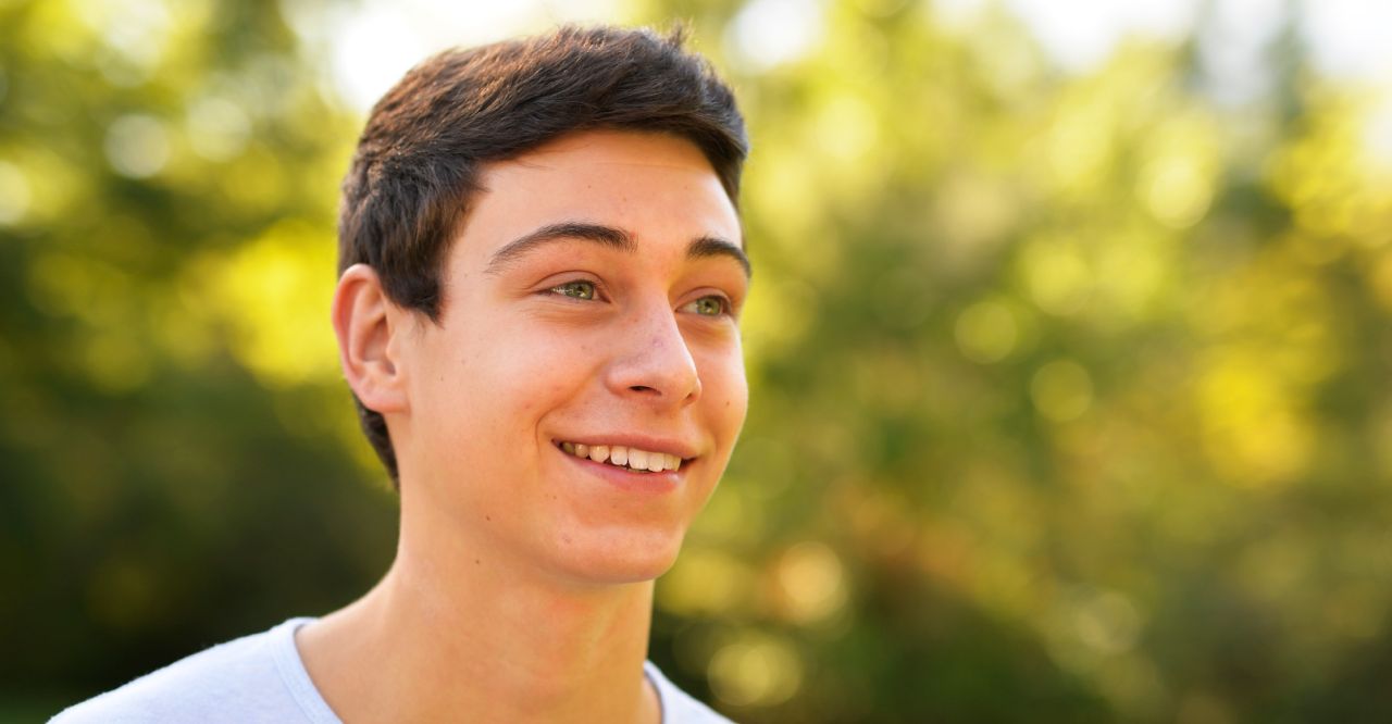 Um jovem sorri ao pensar em suas bênçãos
