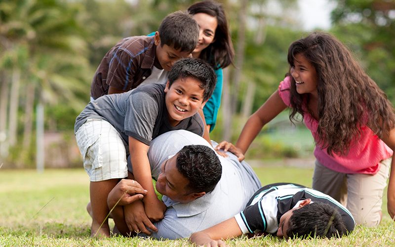Uma família joga futebol em um parque, vivendo a Palavra de Sabedoria