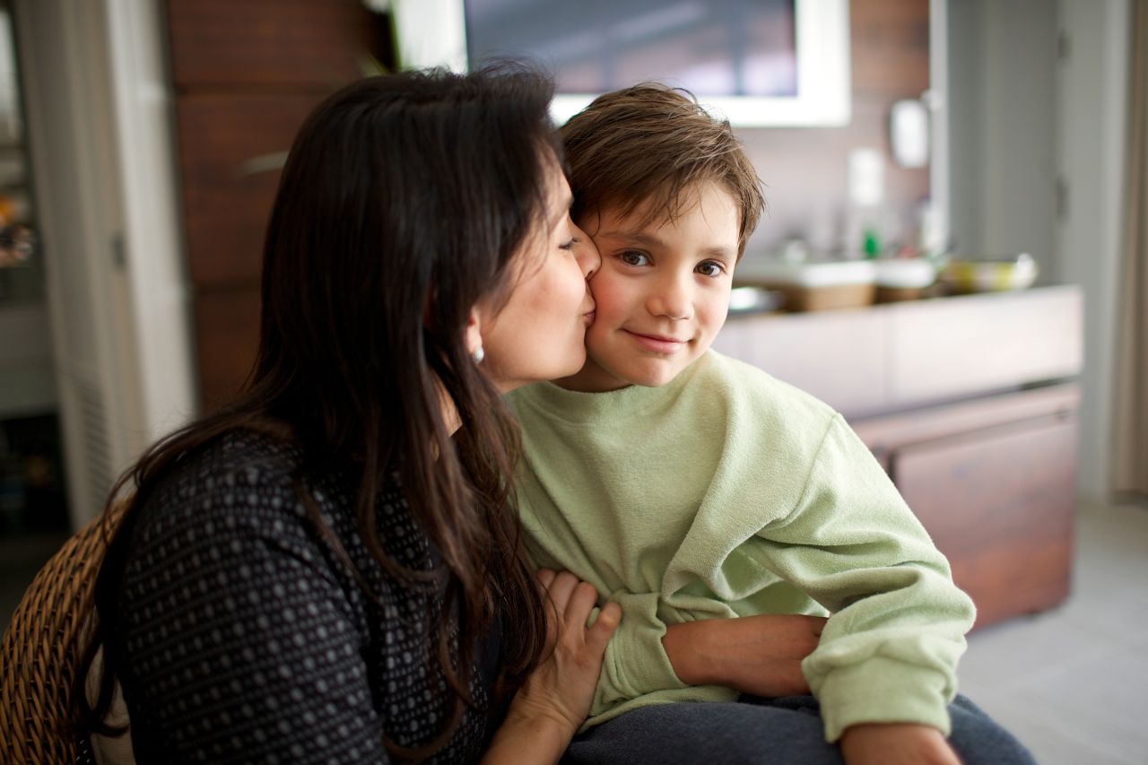 Uma mãe beija seu filho carinhosamente