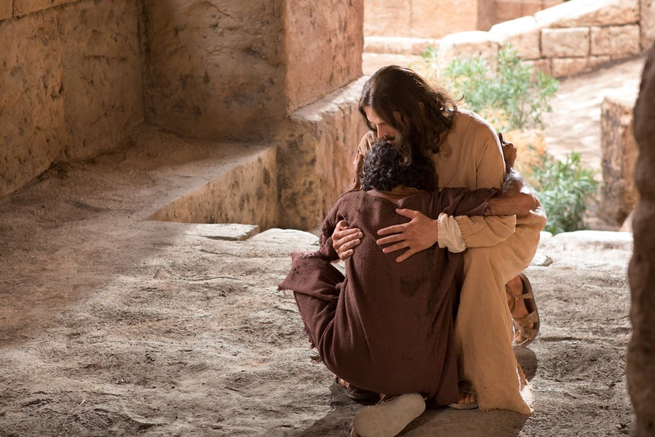 Um homem abraça Jesus enquanto eles caem no chão