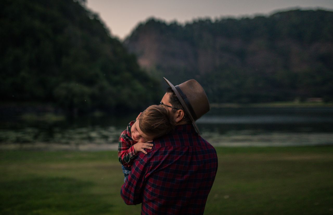 Um pai segura o filho enquanto está na natureza