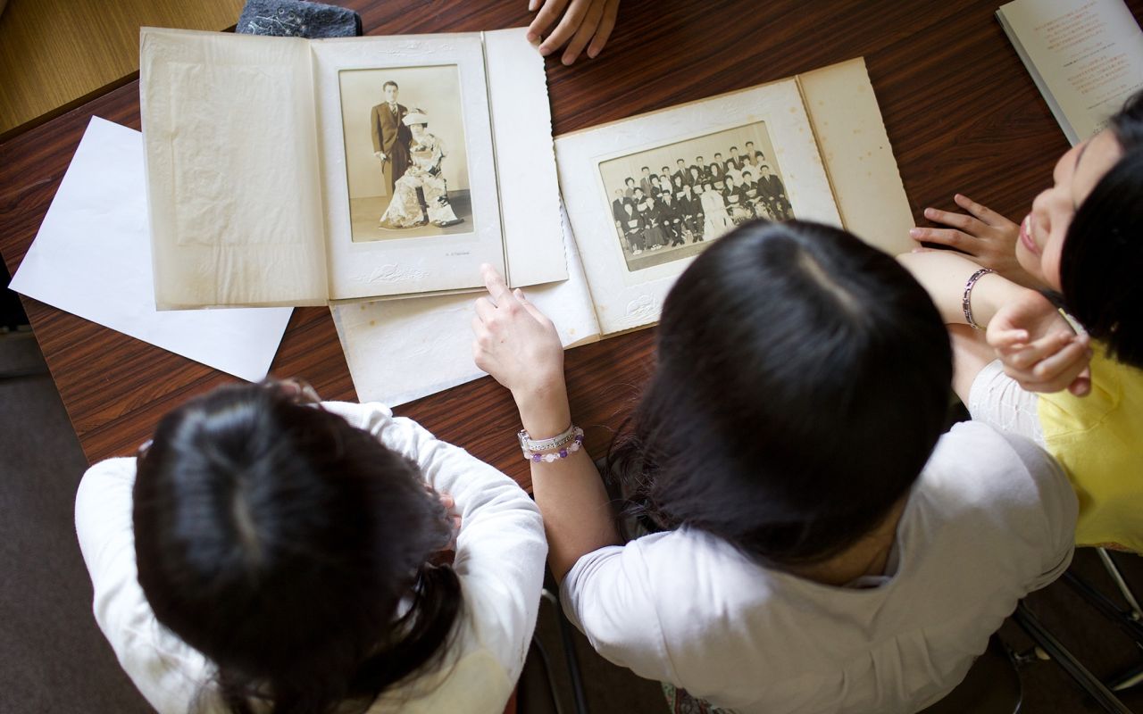 Uma família faz a história da família juntos, folheando livros de recordações