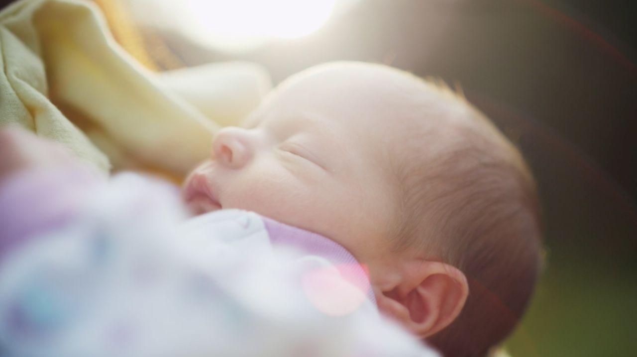 Um pai segurando um bebê recém-nascido
