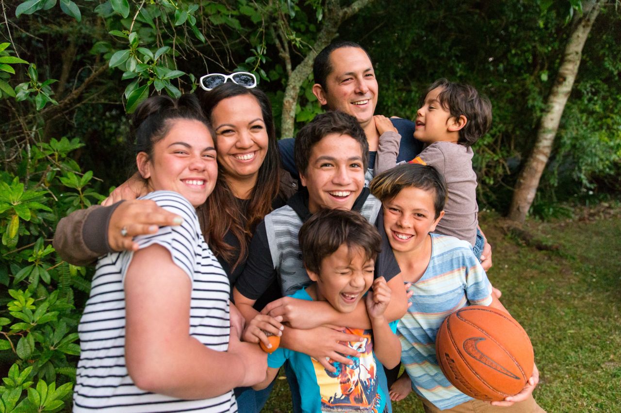 uma família se abraça e sorria