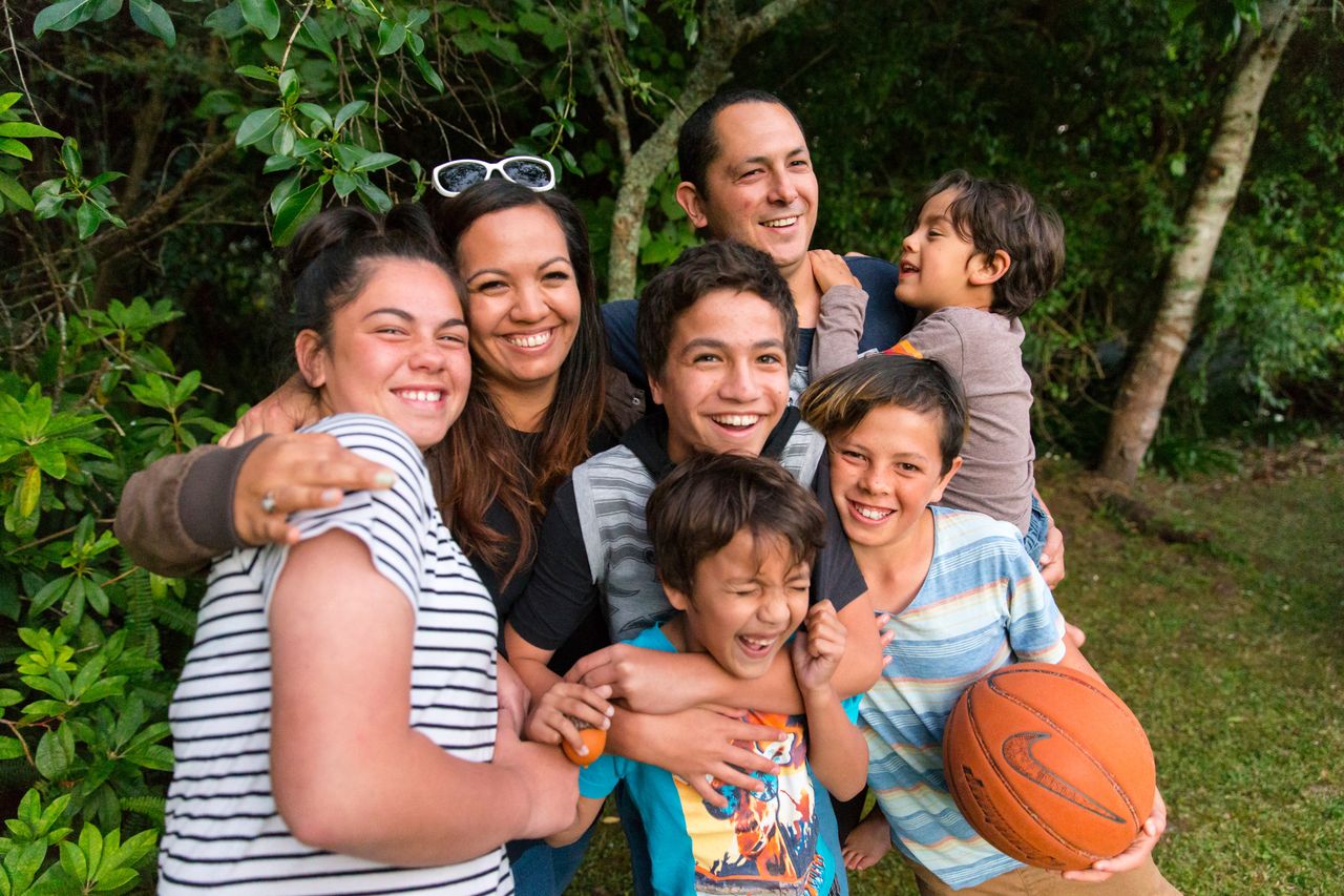 uma família se abraça e sorria
