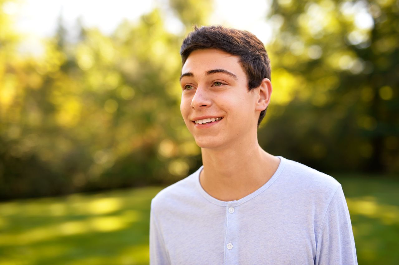 Um jovem sorri ao pensar em suas bênçãos