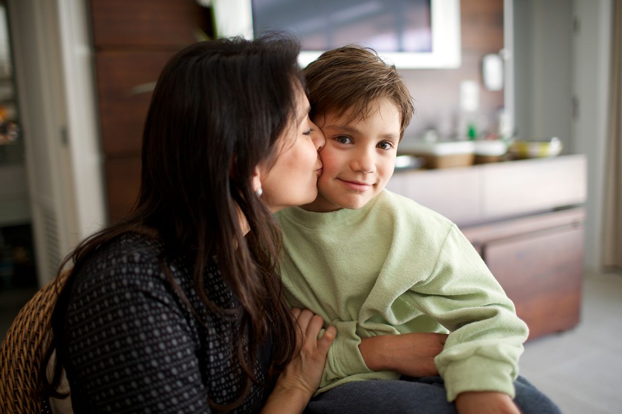 Uma mãe beija seu filho carinhosamente
