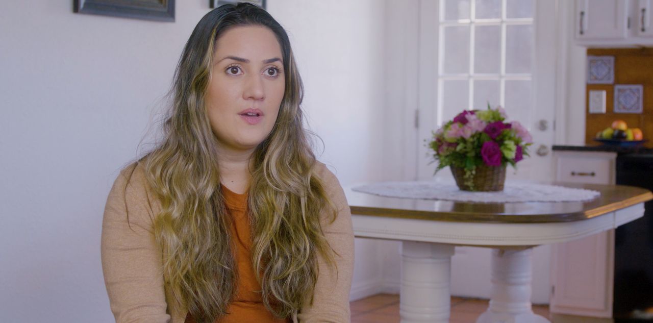 Uma mulher sendo entrevistada em sua cozinha